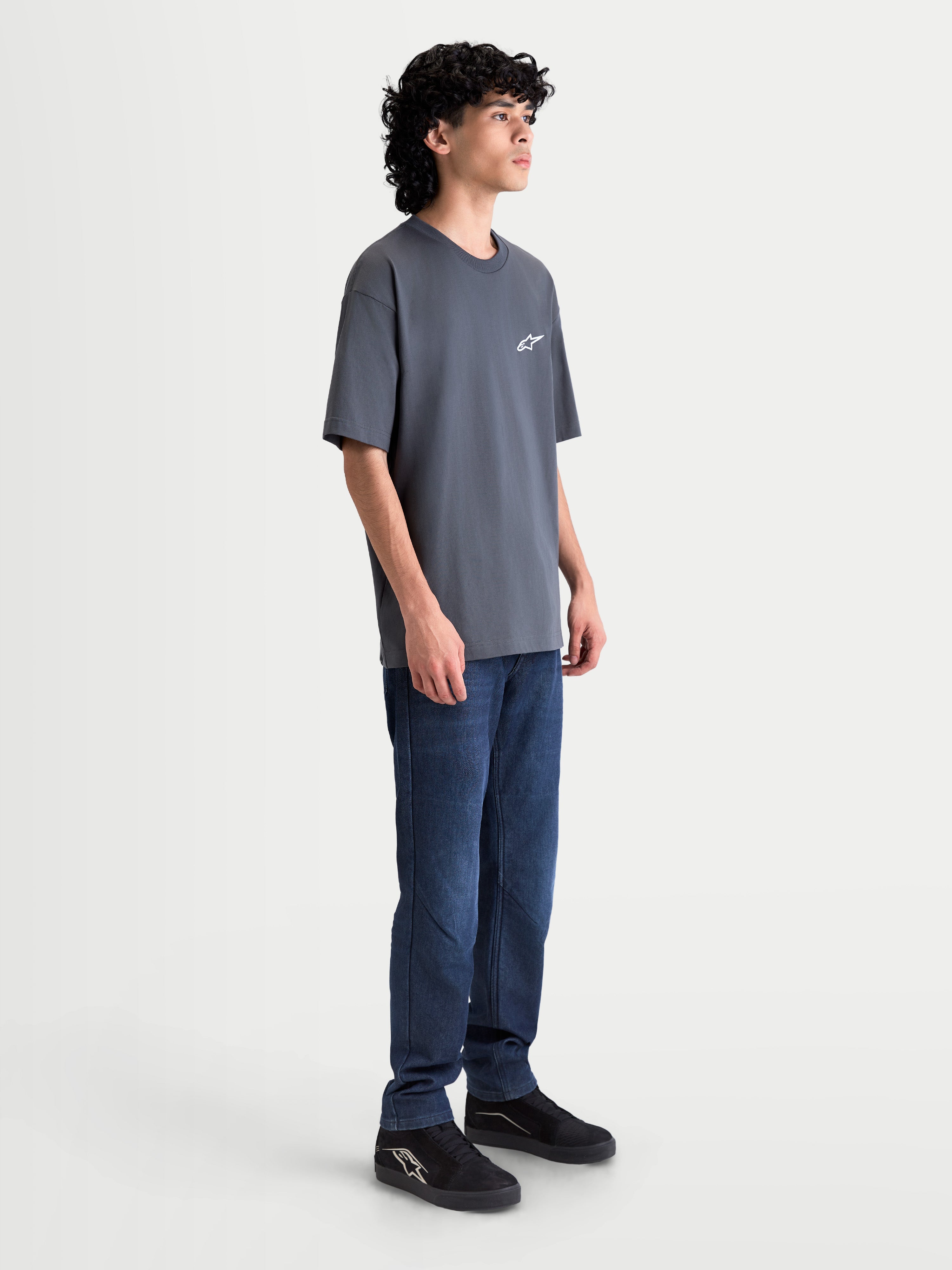 Alpinestars Mandate Oversized CSF T-shirt, unisex kortærmet sportstøj, grå, afslappet oversized pasform og puff-print Astars-logo, vist fra siden på model.