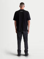 Alpinestars Prelude Oversized CSF T-shirt, sort kortærmet T-shirt med oversized pasform, hvidt Alpinestars-logografik på øverste del af ryggen, set bagfra på model, afslappet motorsport sportstøj.