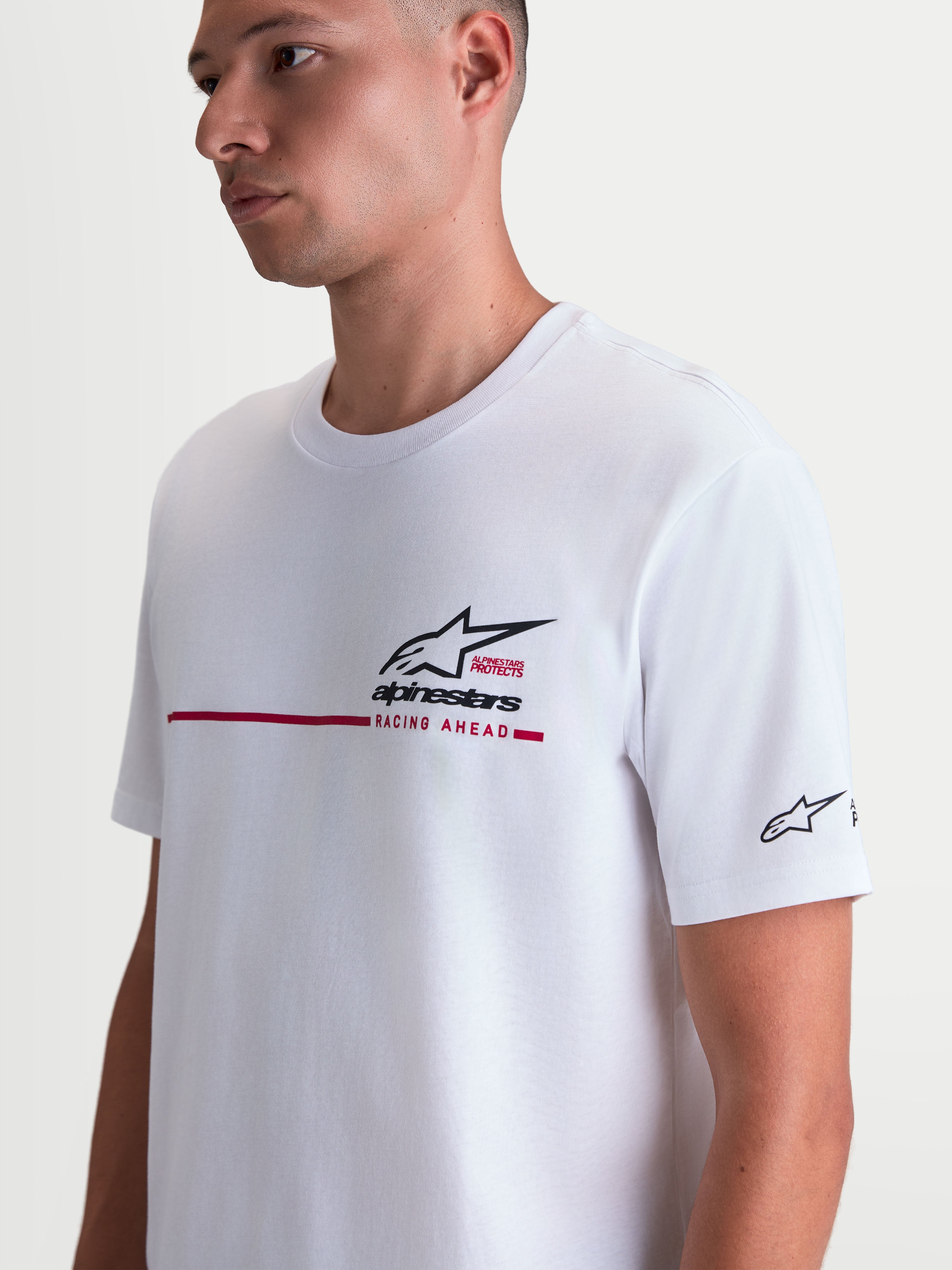 Alpinestars P1 CSF T-shirt, hvid kortærmet T-shirt med sort Astars-logo og rød race-stribe på brystet, vist på model, afslappet motorsport-sportstøj i blød bomulds- og polyesterblanding.