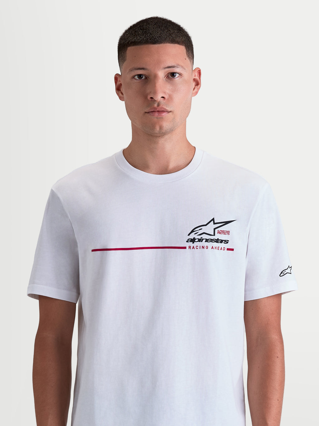 Alpinestars P1 CSF T-shirt, hvid kortærmet t-shirt med rød race-stribe, sort Astars-logo og 'Racing Ahead' tekst på brystet, blød bomulds- og polyesterblanding, afslappet motorsport sportswear.