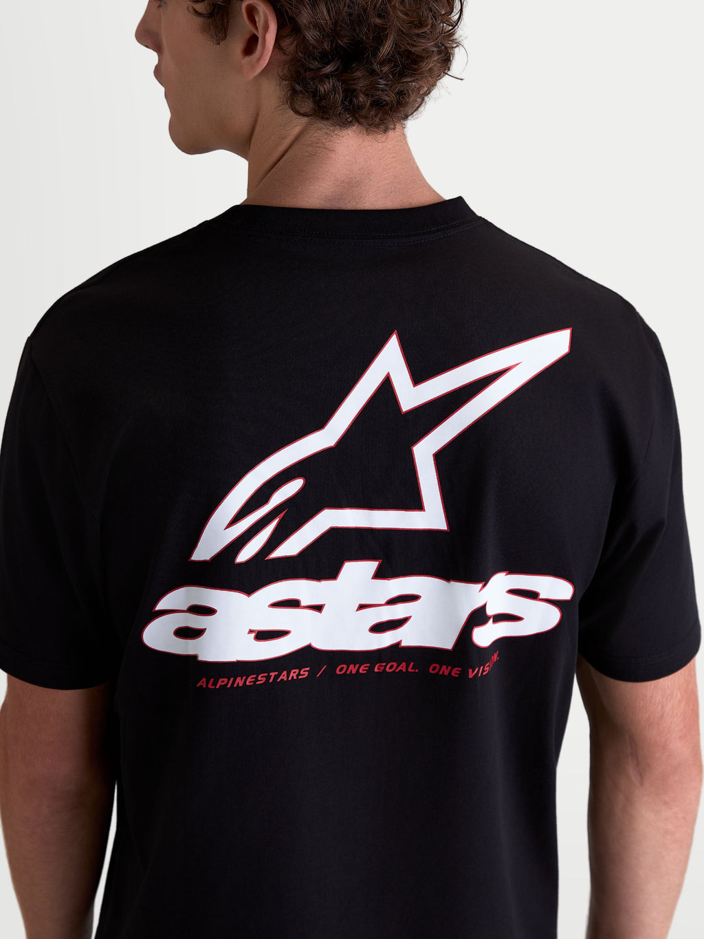 Alpinestars Lineout CSF t-shirt, sort kortærmet t-shirt set bagfra med stort hvidt og rødt Astars-logo på ryggen, herunder brand-mottoet One Goal One Vision, afslappet motorsportstøj i en blød bomulds- og polyesterblanding.