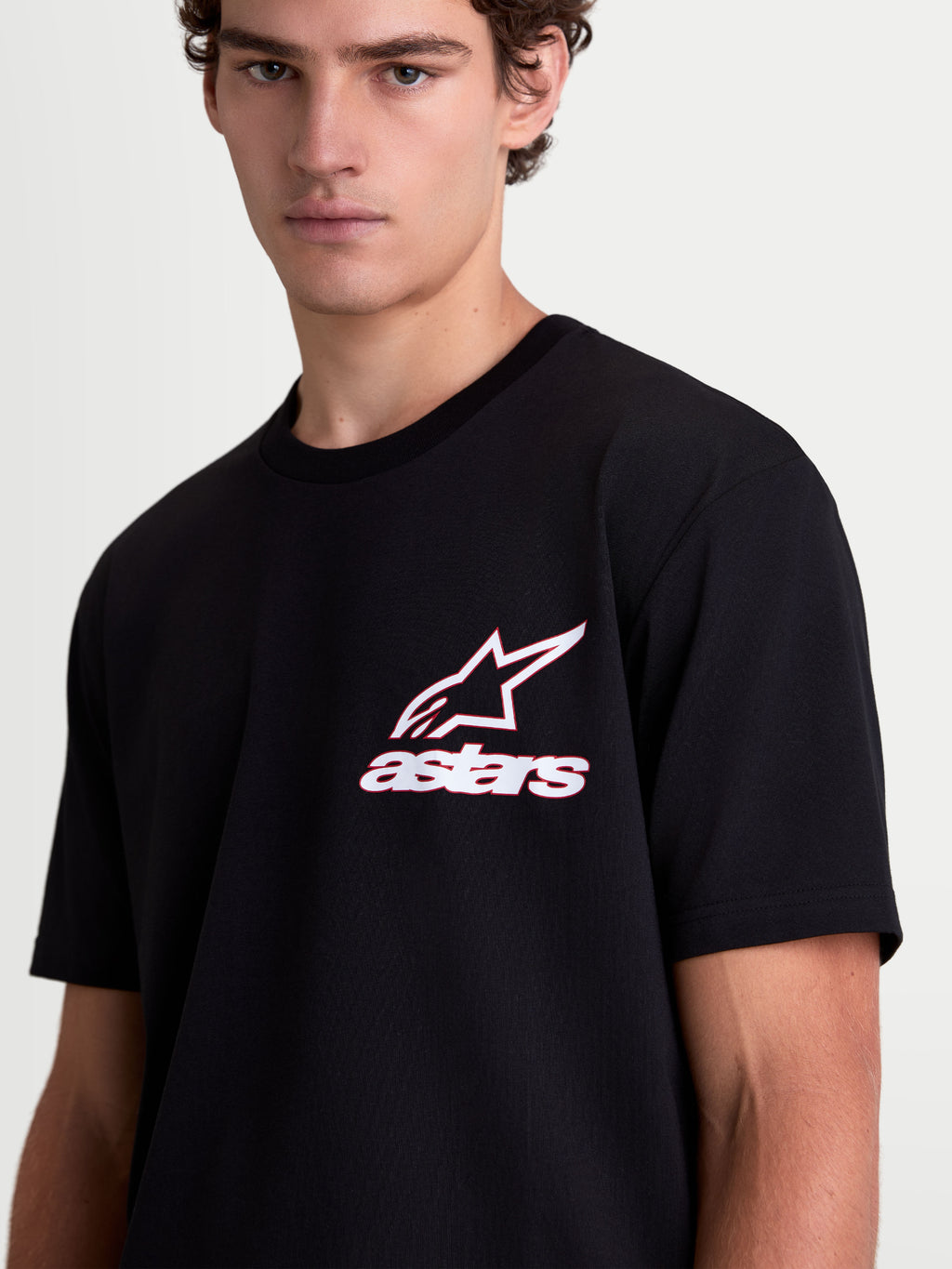 Alpinestars Lineout CSF T-shirt, kortærmet sportswear-T-shirt på model, sort med hvid og rød Astars-logografik, blød bomulds-polyesterblanding, afslappet motorsport-livsstil.