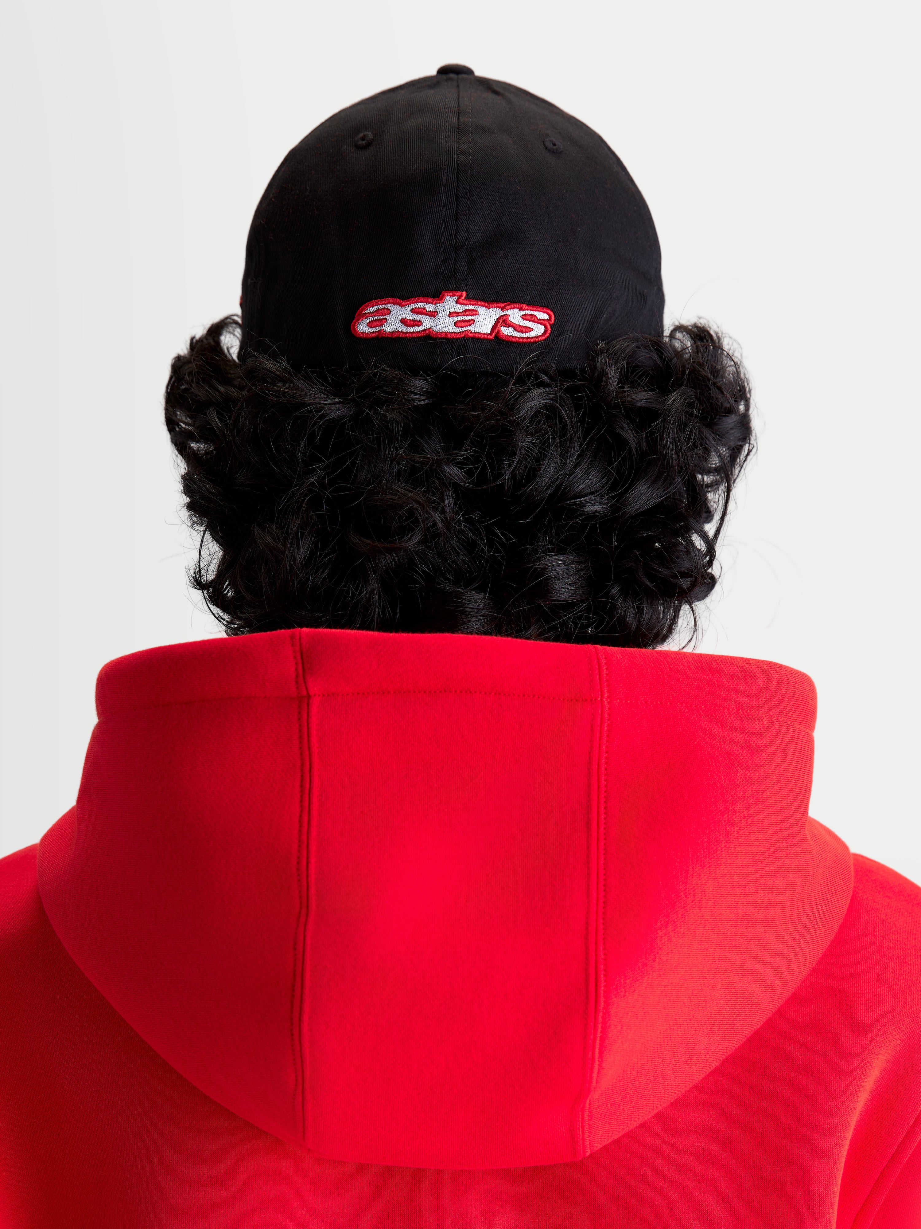 Alpinestars Lineout kasket, sportswear baseballkasket, sort og rød, set bagfra på model med broderet Astars-logo, struktureret krone og twill-konstruktion.