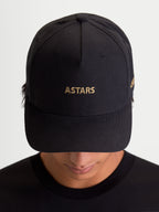 Alpinestars County Canvas Kasket, sort sportswear-kasket med guld ASTARS-logobroderi, buet skygge og struktureret krone, motorsport-inspireret kasket til hverdagsbrug i peached oxford-stof, set forfra på model
