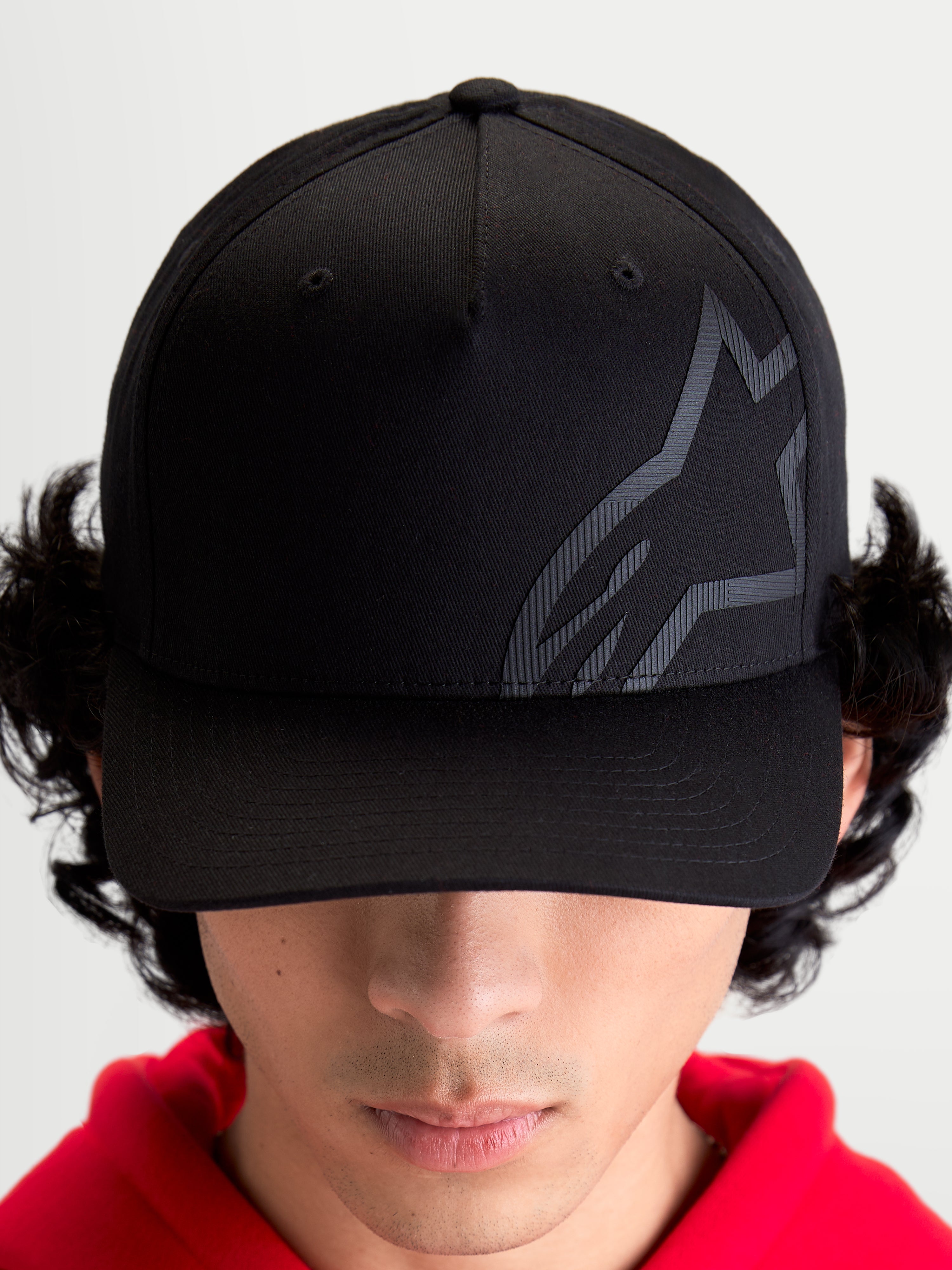 Alpinestars Maze kasket, motorsport-inspireret baseballkasket til sportstøj, unisex, sort, twillstof med struktureret krone, buet skygge og tekstureret tonalt Astars Corp Shift-logo, set forfra på model.