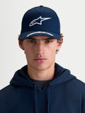 Alpinestars Arclight kasket, sportswearkasket med buet skygge, marineblå og hvid, set forfra på model, struktureret krone, tekstureret puff-print Astars-logo, premium bomuldstwill