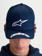 Alpinestars Arclight kasket, motorsportinspireret sportswear-kasket til herre og dame, mørkeblå og hvid, struktureret krone med tekstureret puff-print Astars-logo, buet skygge med Astars-detalje, slidstærk bomuldstwill, set forfra på model.