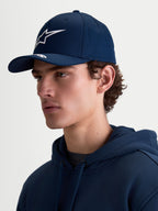 Alpinestars Arclight kasket, navyblå sportswearkasket til mænd og kvinder, hvidt Astars puff-print logo, buet skygge og struktureret krone i bomuldstwill, sideprofil på model med et klassisk motorsportsinspireret look.