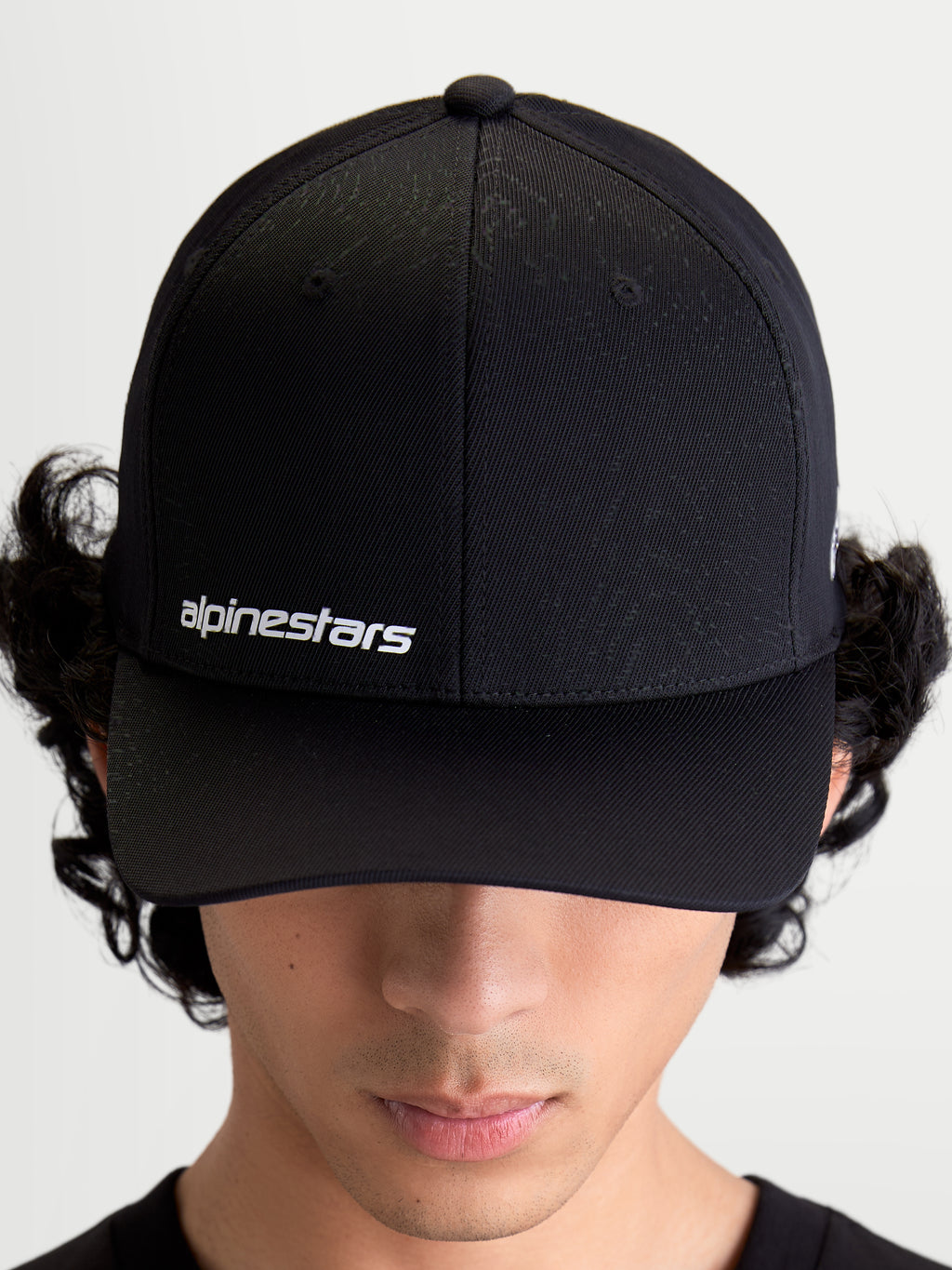 Alpinestars Points kasket, sort kasket med buet skygge på model, hvidt Alpinestars ordlogo på fronten, let nylon tactel-materiale, sportswear til hverdagsbrug.