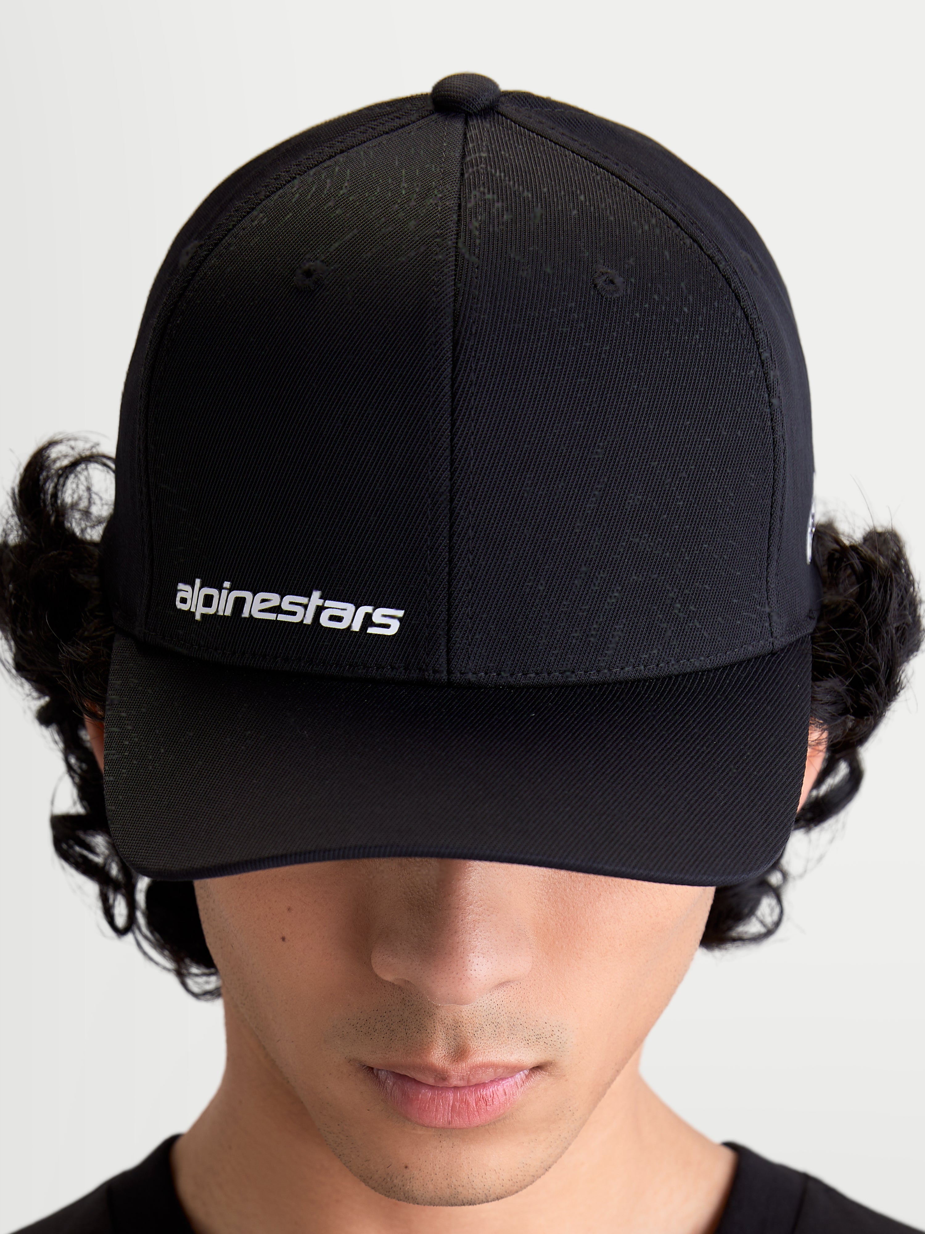 Alpinestars Points kasket, sort kasket med buet skygge på model, hvidt Alpinestars ordlogo på fronten, let nylon tactel-materiale, sportswear til hverdagsbrug.