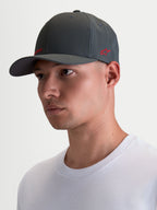 Alpinestars Points kasket på model, mørkegrå sportswear-kasket med bueformet skygge og rødt logo, let nylon tactel materiale, flex-back pasform til hverdagsbrug.