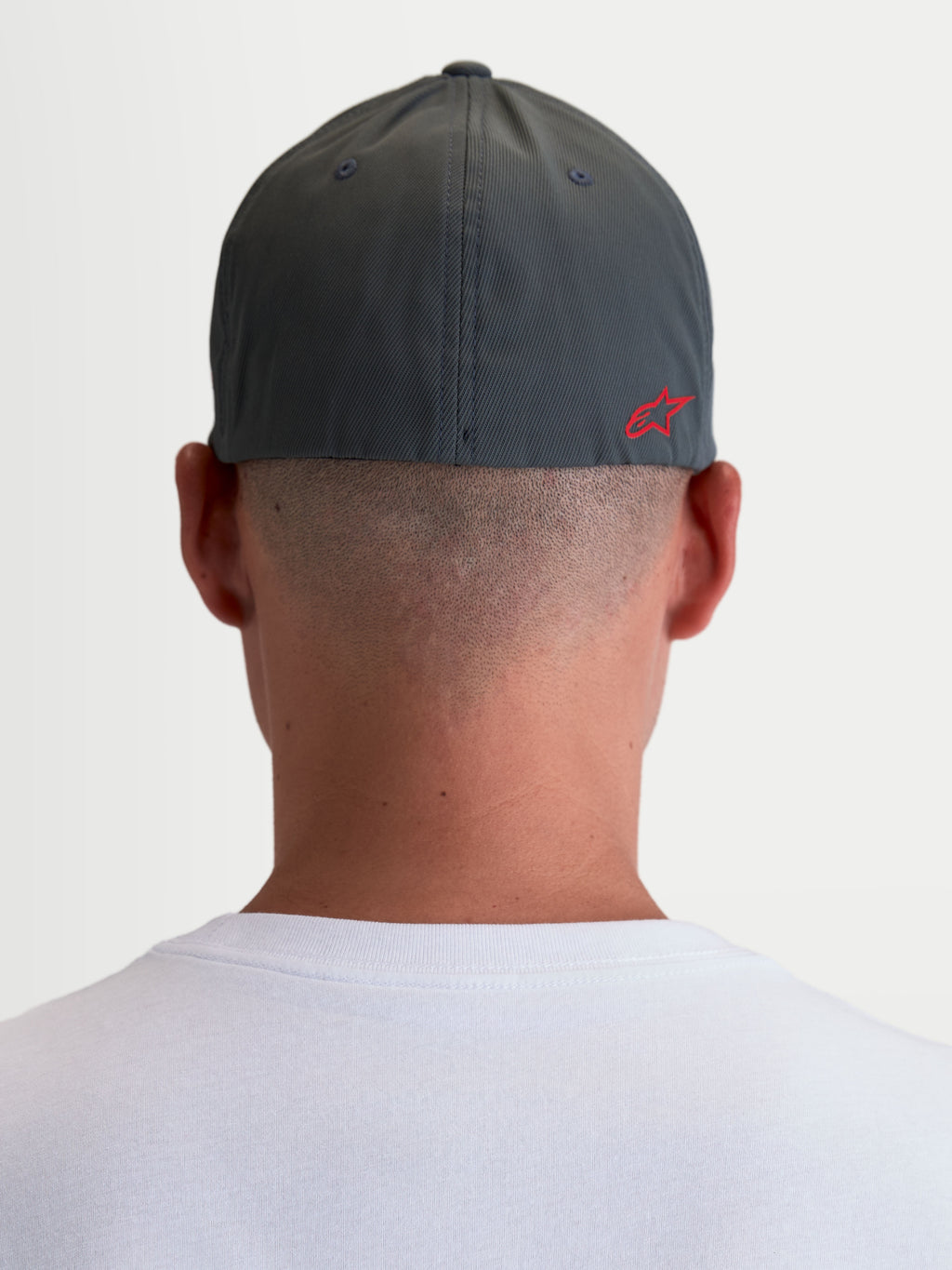 Alpinestars Points kasket, unisex sportstøjskasket set bagfra på model, mørkegrå og rød, letvægts nylon tactel med flex-back pasform og rødt Astars HD-logo.