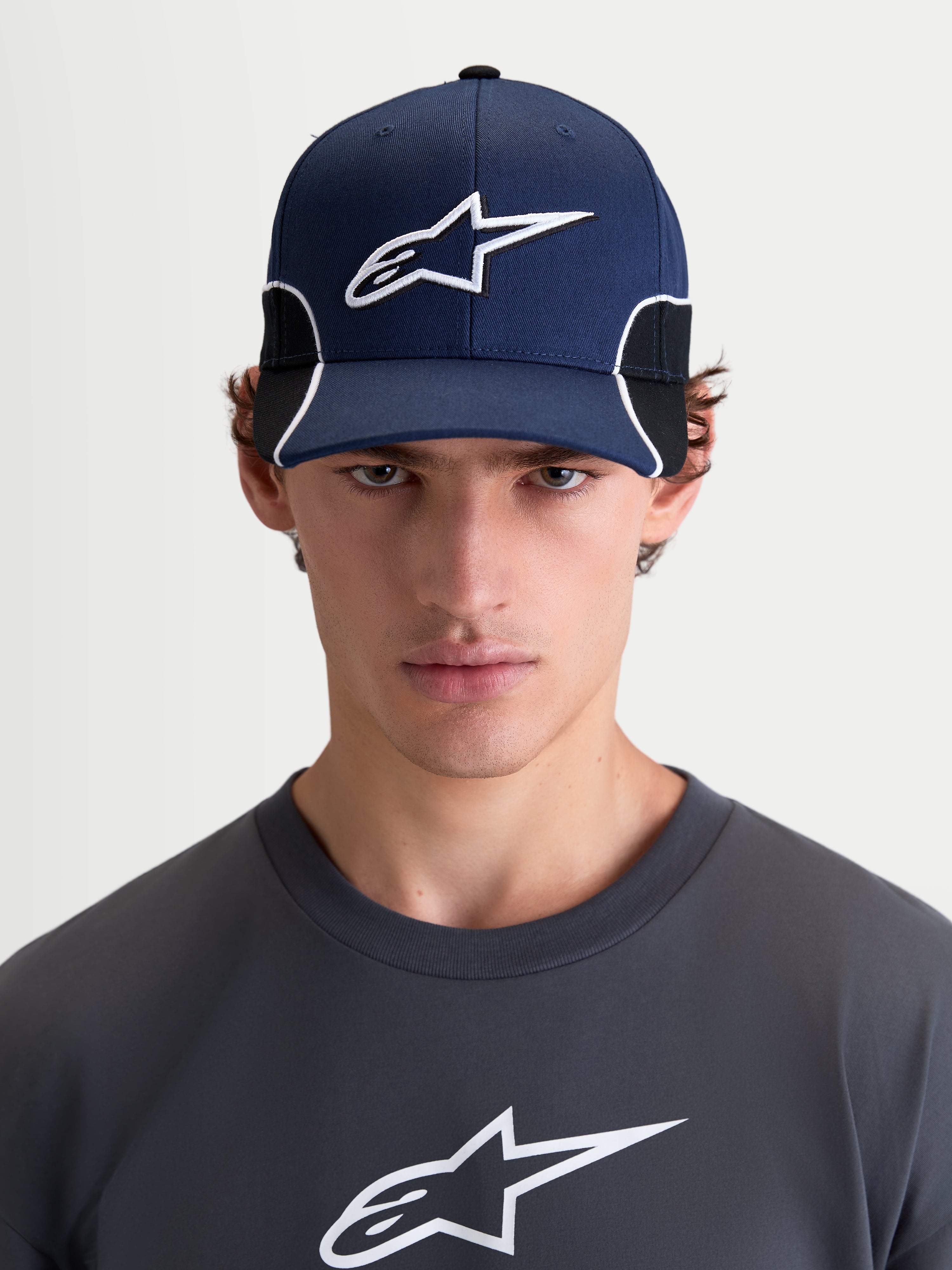 Alpinestars 500 Snapback kasket, sportswear kasket til herrer, navyblå og sort, buet skygge og struktureret krone med 3D-broderet Astars-logo og hvid kontrastpiping, set forfra på model.