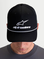 Alpinestars Combo Logo Snapback kasket, sort kasket vist på model med hvidt broderet Astars-logo og hvid dekorativ snor, struktureret krone og buet skygge, unisex afslappet sportswear til motorsport.