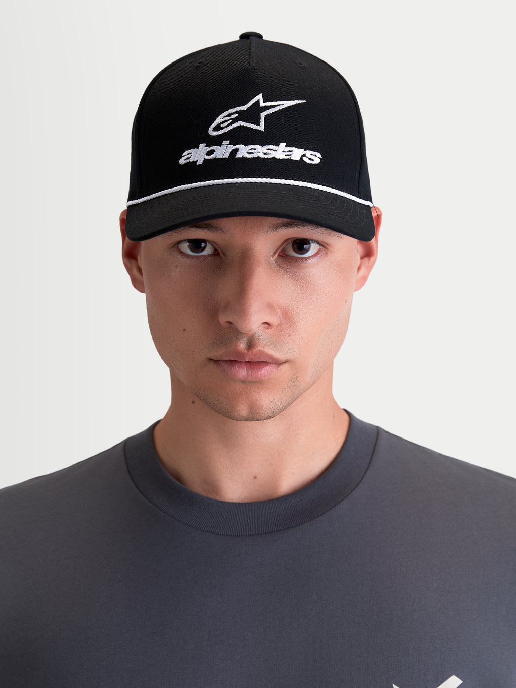 Alpinestars Combo Logo Snapback kasket, motorcykel sportswear kasket, unisex, sort og hvid, med buet skygge, struktureret krone og broderet Astars-logo, 100 % bomuldstwill, set forfra på model.