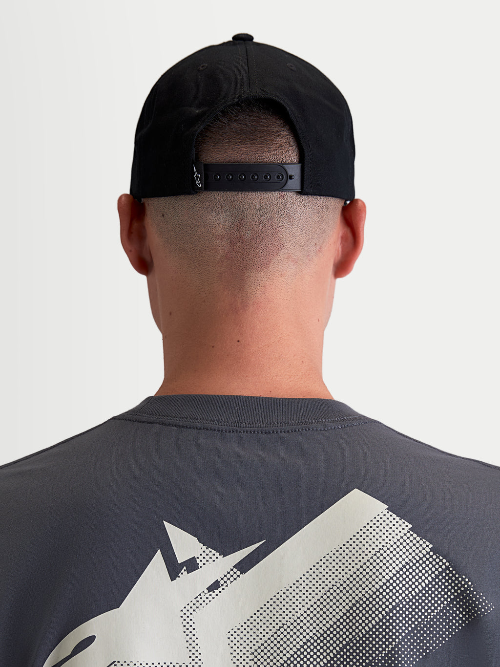 Alpinestars Combo Logo Snapback kasket, motorsport-inspireret sportswear-kasket, sort, slidstærk bomuldstwill, set bagfra på model der viser den justerbare snapback-lukning og lille hvidt broderet Astars-logo.