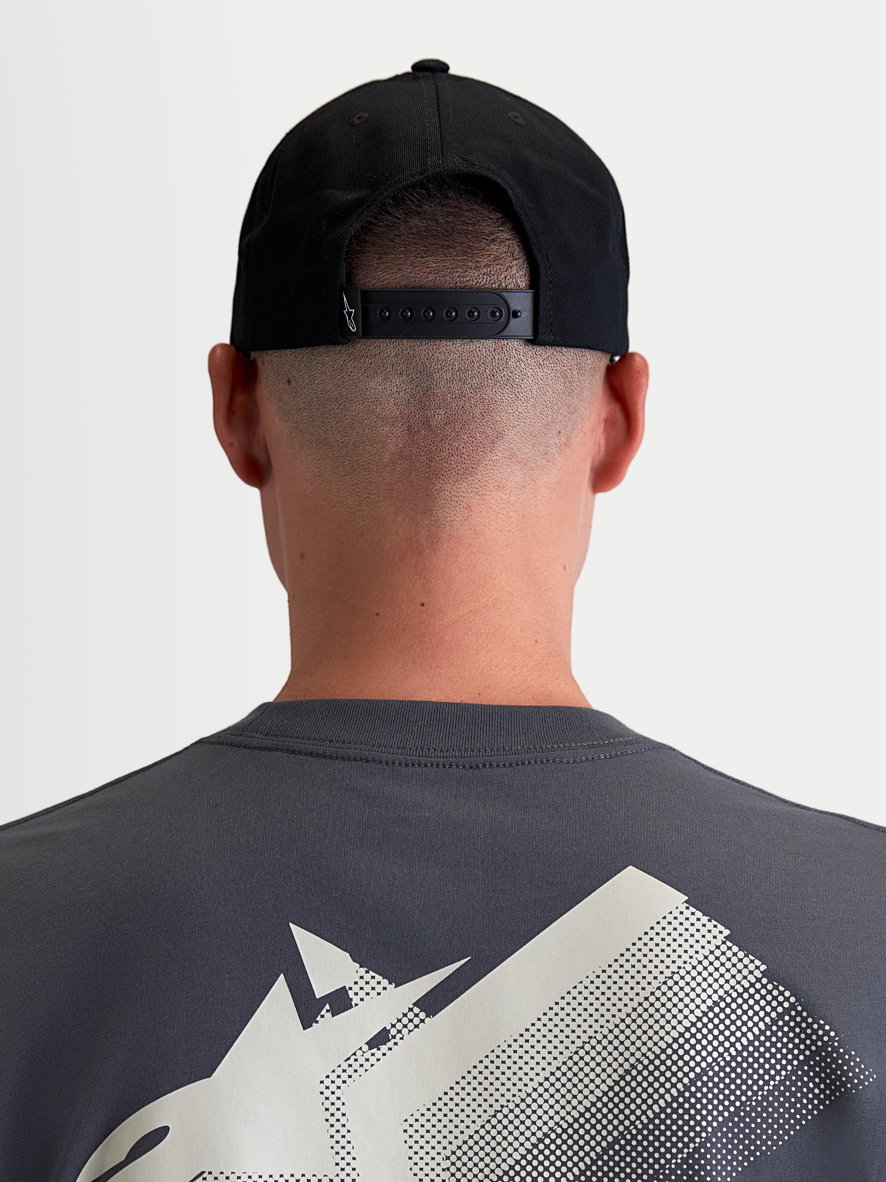 Alpinestars Combo Logo Snapback kasket, motorsport-inspireret sportswear-kasket, sort, slidstærk bomuldstwill, set bagfra på model der viser den justerbare snapback-lukning og lille hvidt broderet Astars-logo.