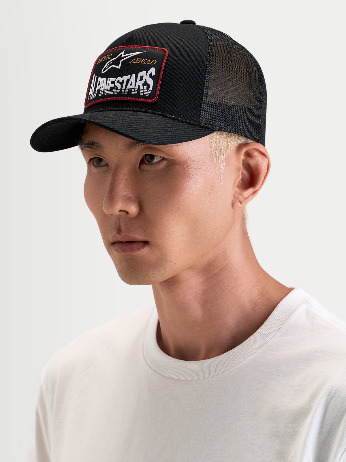 Alpinestars Hemmings Trucker cap, sort sportswear kasket med åndbart poly mesh bagpå og vævet logomærke foran, båret af mandlig model