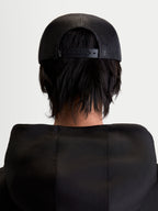 Alpinestars Gravel Trucker cap, sportswear snapback cap, sort, unisex, set bagfra på model med åndbar poly mesh-bagside og justerbar snapback-lukning.