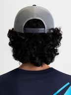Alpinestars Gravel Trucker cap, grå og sort kasket til sportstøj, set bagfra på model, viser den åndbare poly mesh-bagside og justerbar snapback-lukning for en personlig pasform.