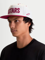 Alpinestars Stadium Snapback kasket, sportswear-kasket, hvid og rød, med flad skygge, struktureret krone og Astars logoapplikation med kontraststikninger og sidebroderi, vist på model.