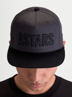 Alpinestars Stadium Snapback kasket, motorsport-inspireret sportswear-kasket vist på model, mørkegrå og sort, flad skygge og struktureret krone med broderet ASTARS-logo og kontrastsøm i slidstærk bomuldstwill.