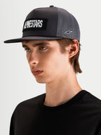 Alpinestars Ten Trucker Cap, mørkegrå sportswear-kasket med flad skygge, båret af model, med broderet Alpinestars-ordlogo-patch foran og Astars-logo i siden