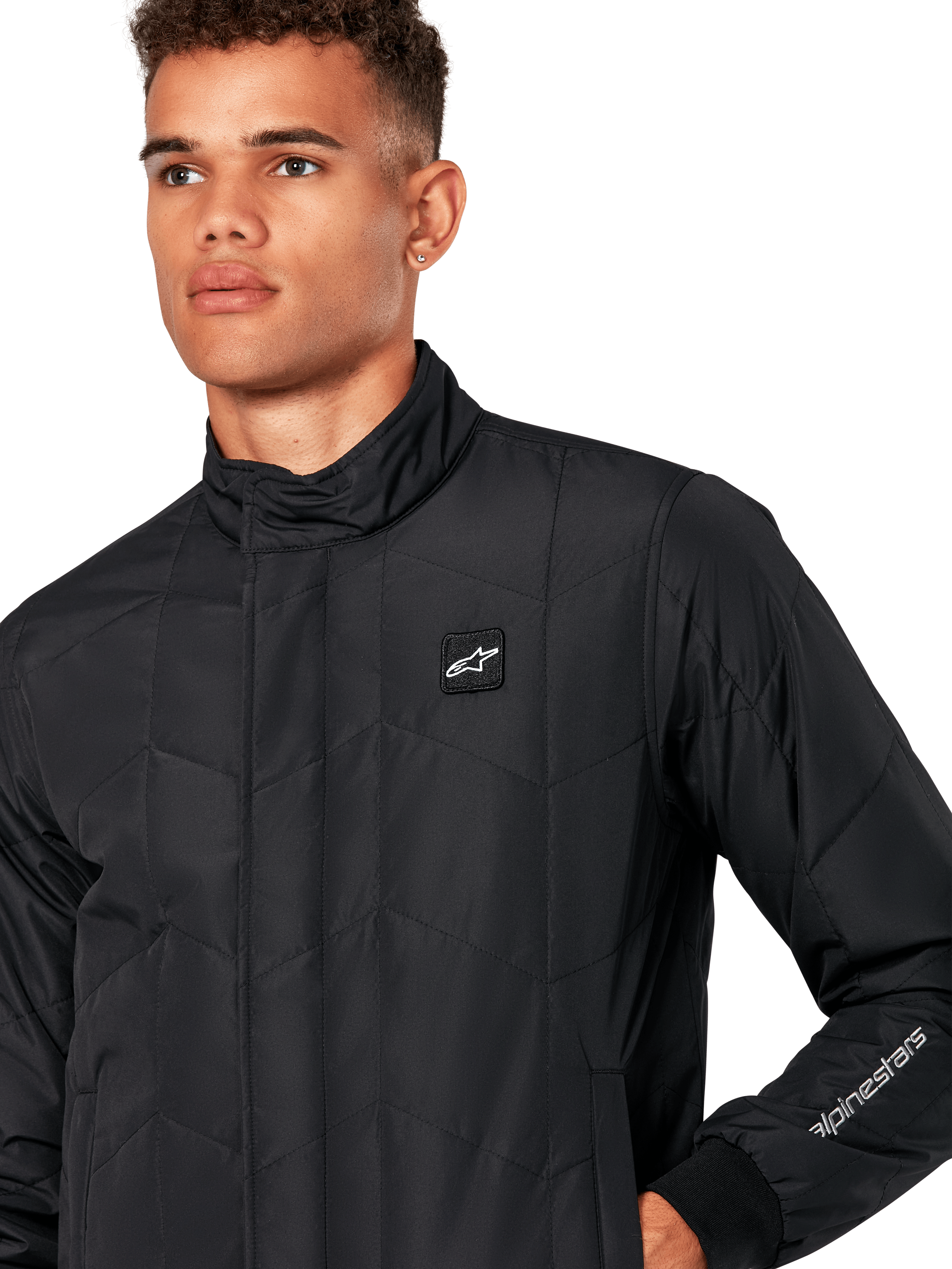 Alpinestars Precedent Jacket, Men's Quilted Sportswear Jacket in Black, close-up showing the low track collar, chest logo patch, and sleeve embroidery, featuring an iconic angled quilt pattern for a motorsport-inspired look.