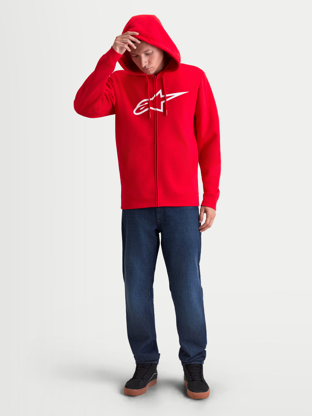 Alpinestars Ageless Zip V3 Hættetrøje, rød og hvid herre-sportshættetrøje med lynlås i fleece på model, hvidt Alpinestars brystlogo, hætte med snoretræk og ribkanter, afslappet motorsport streetwear