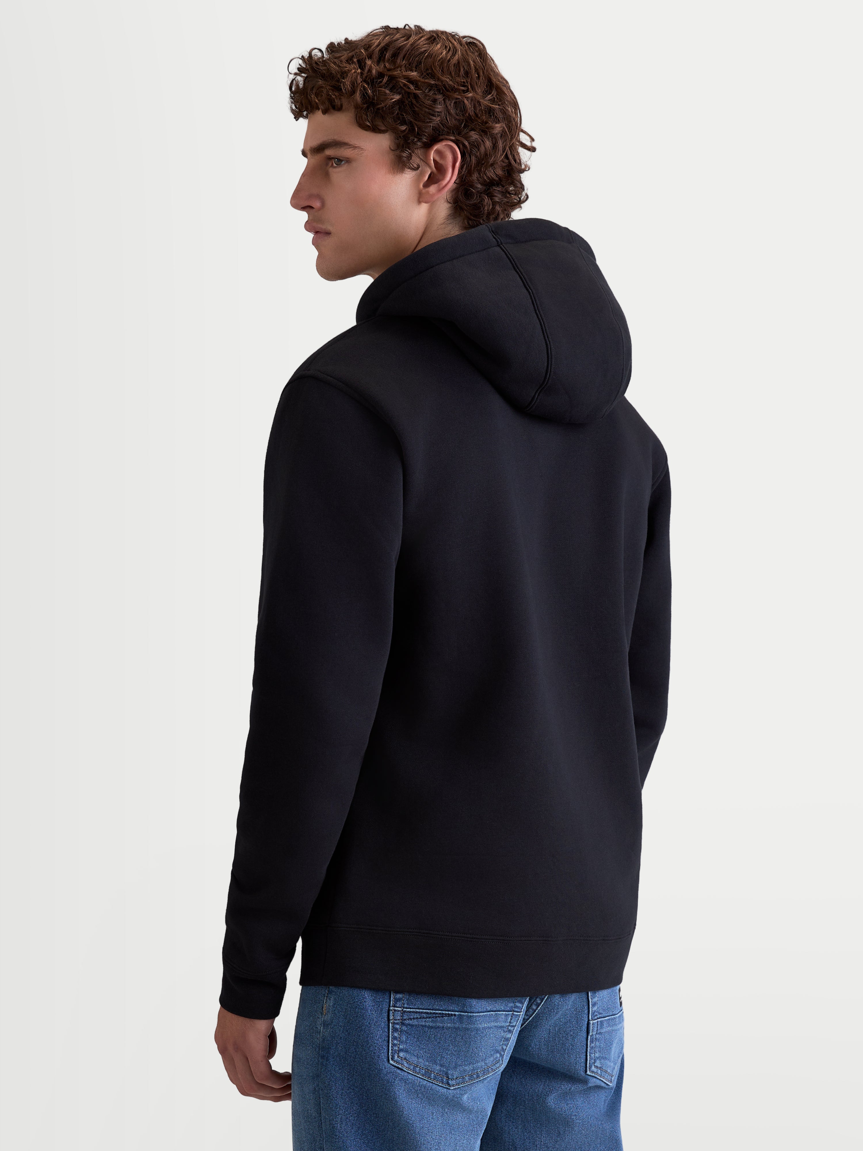 Alpinestars Ageless V3 Hættetrøje, herre-sportswear hoodie i sort fleece, set bagfra med fokus på hættedesign og ribmanchetter, behageligt hverdagstøj til motorsportsentusiaster.