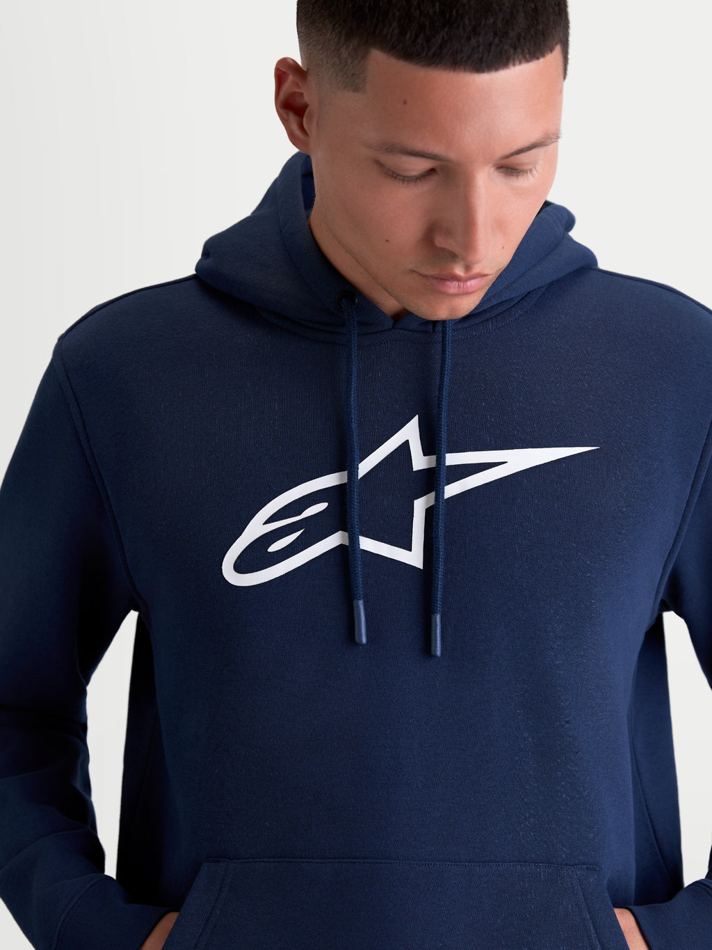 Alpinestars Ageless V3 hættetrøje, mørkeblå og hvid, herre-sportstøj pullover i blød fleece med et stort hvidt broderet Alpinestars-logo på brystet, hætte med snoretræk, casual motorsport livsstil.