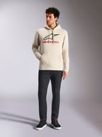 Alpinestars Always V3 hættetrøje, afslappet streetwear, råhvid med sort stjernelogo og rød skrift, hætte med snøre, lange ærmer, båret af mandlig model med sorte bukser og sorte sneakers