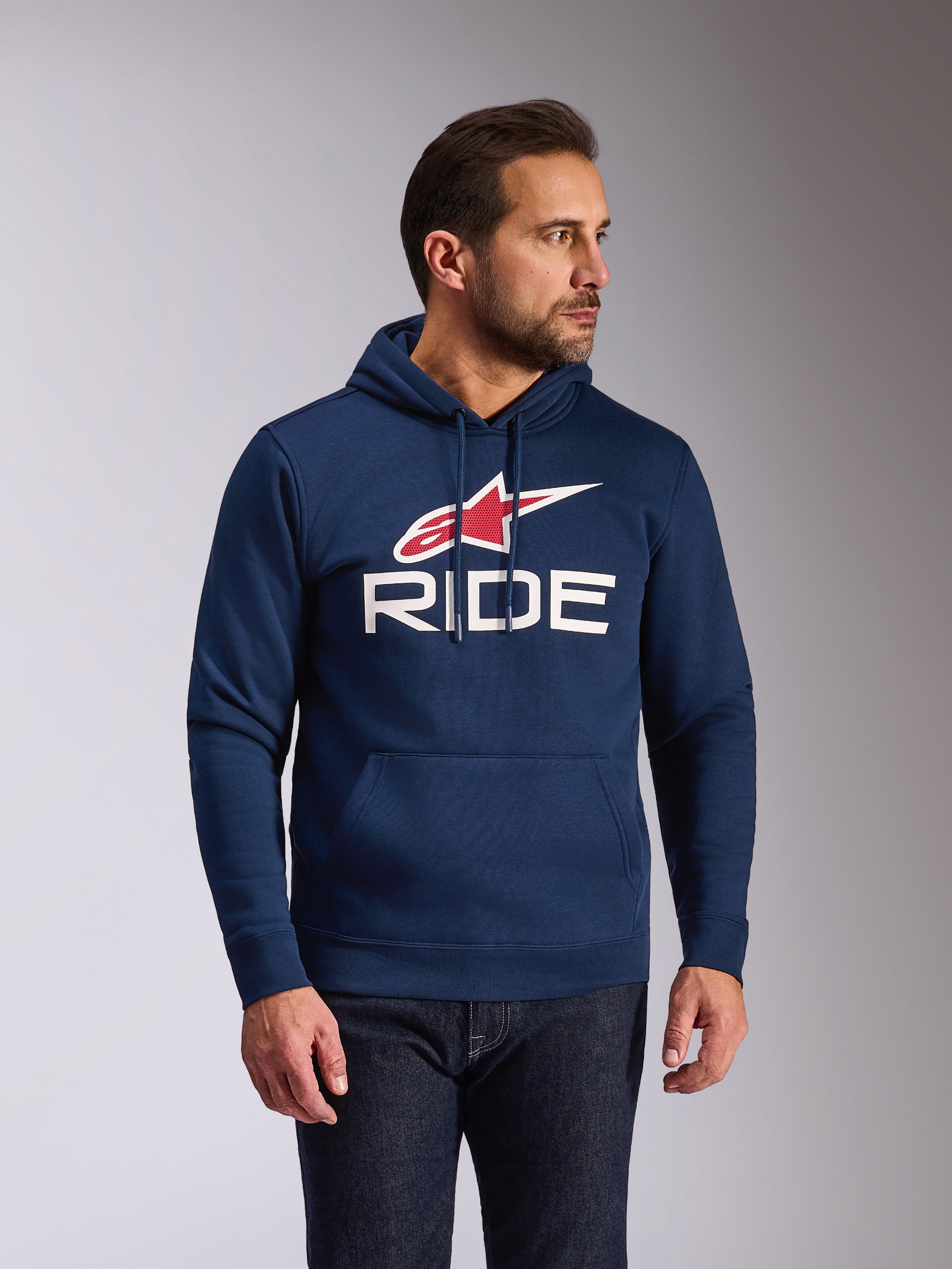 Alpinestars Ride V3 hættetrøje, afslappet navyblå pullover-fleece, med hvidt RIDE-logo og rødt Alpinestars-stjernesymbol, jersey-foret hætte med snoretræk, kængurulomme foran, moderne motorsport-inspireret streetwear