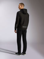 Alpinestars Sessions V3 hættetrøje, sort afslappet streetwear, set bagfra på en model, med gråt Alpinestars-navnetræk på den nederste del af ryggen og Astars-logo på ærmet, design med hætte og lynlås foran, moderne motorsport-inspireret styling