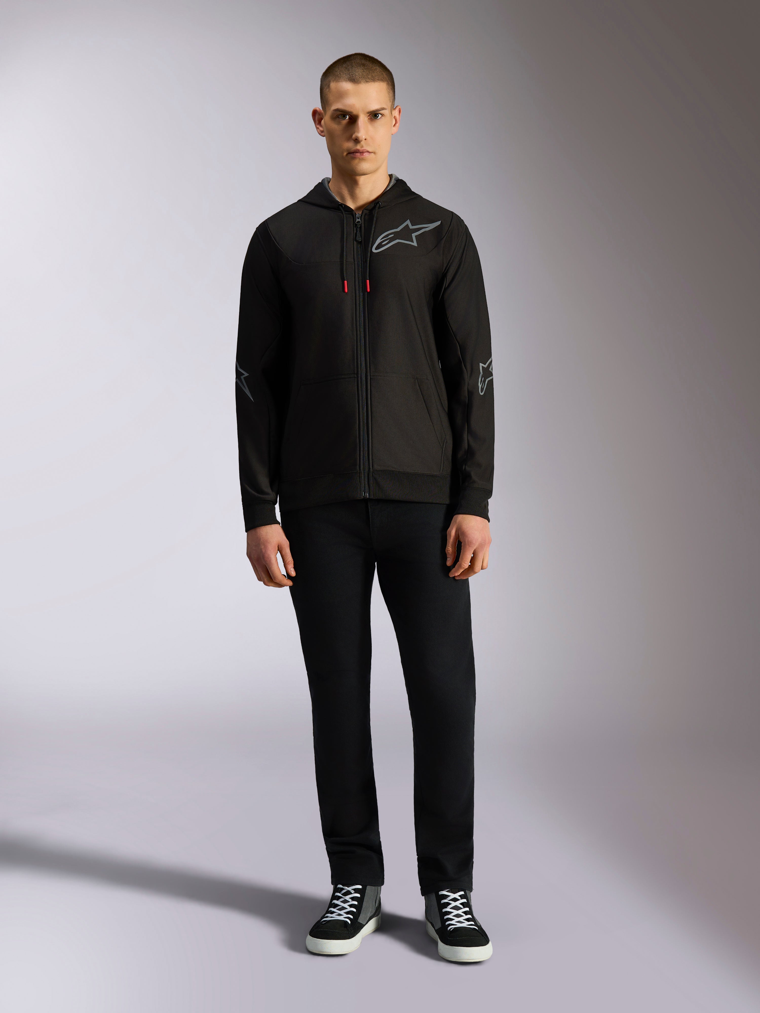 Alpinestars Sessions V3 hættetrøje, fleece-hættetrøje med lynlås foran, sort med gråt Astars-logo på brystet og ærmerne, snoretræk med røde spidser, afslappet motorsport-inspireret streetwear.
