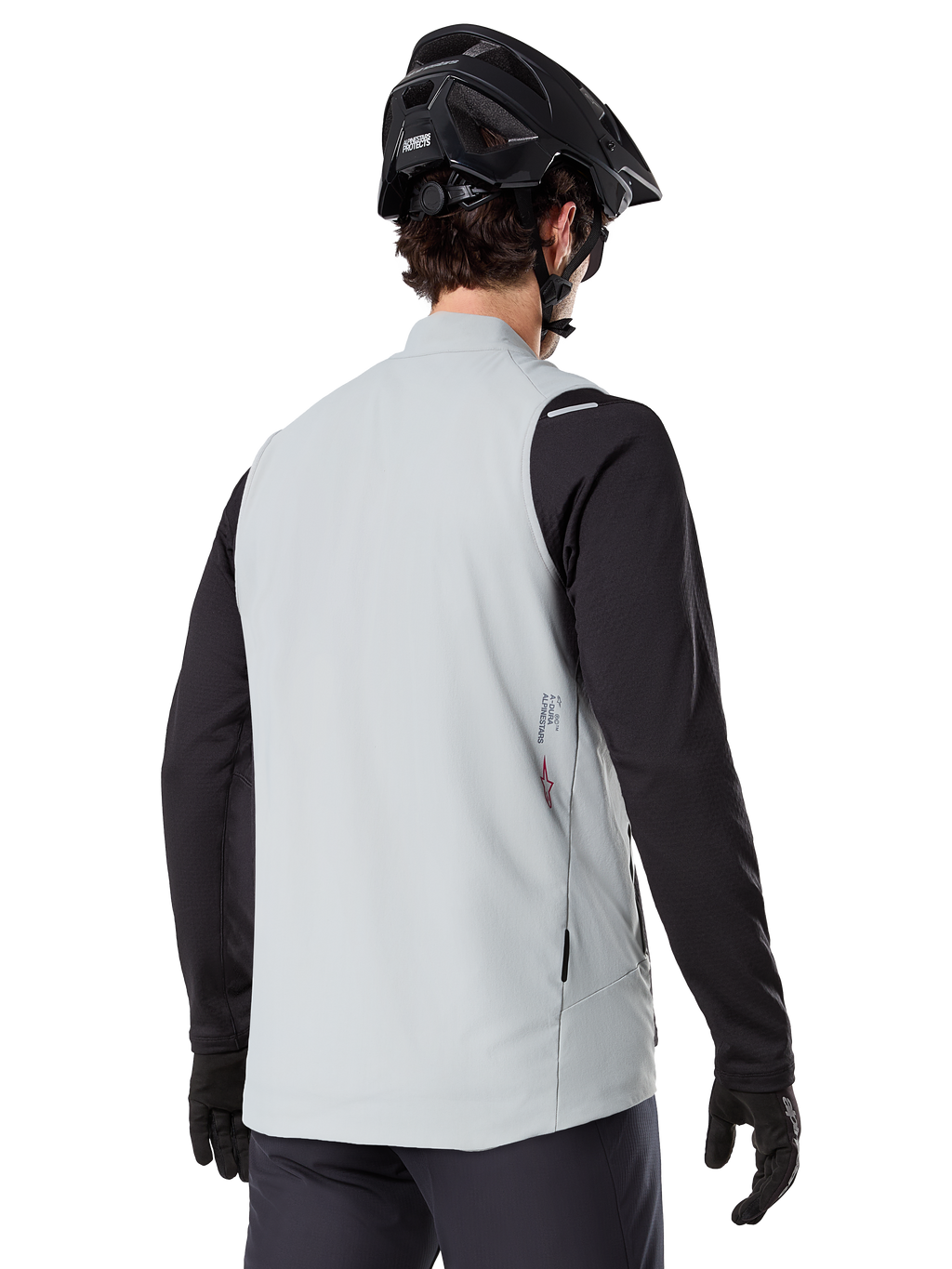 Alpinestars A-Dura Termovest, Titaniumgrå, set bagfra af model iført sort langærmet trøje og MTB-hjelm, minimalistisk design med et lille rødt stjernelogo på ryggen, letvægts isoleret cykelvest til off-road kørsel