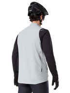 Alpinestars A-Dura Termovest, Titaniumgrå, set bagfra af model iført sort langærmet trøje og MTB-hjelm, minimalistisk design med et lille rødt stjernelogo på ryggen, letvægts isoleret cykelvest til off-road kørsel