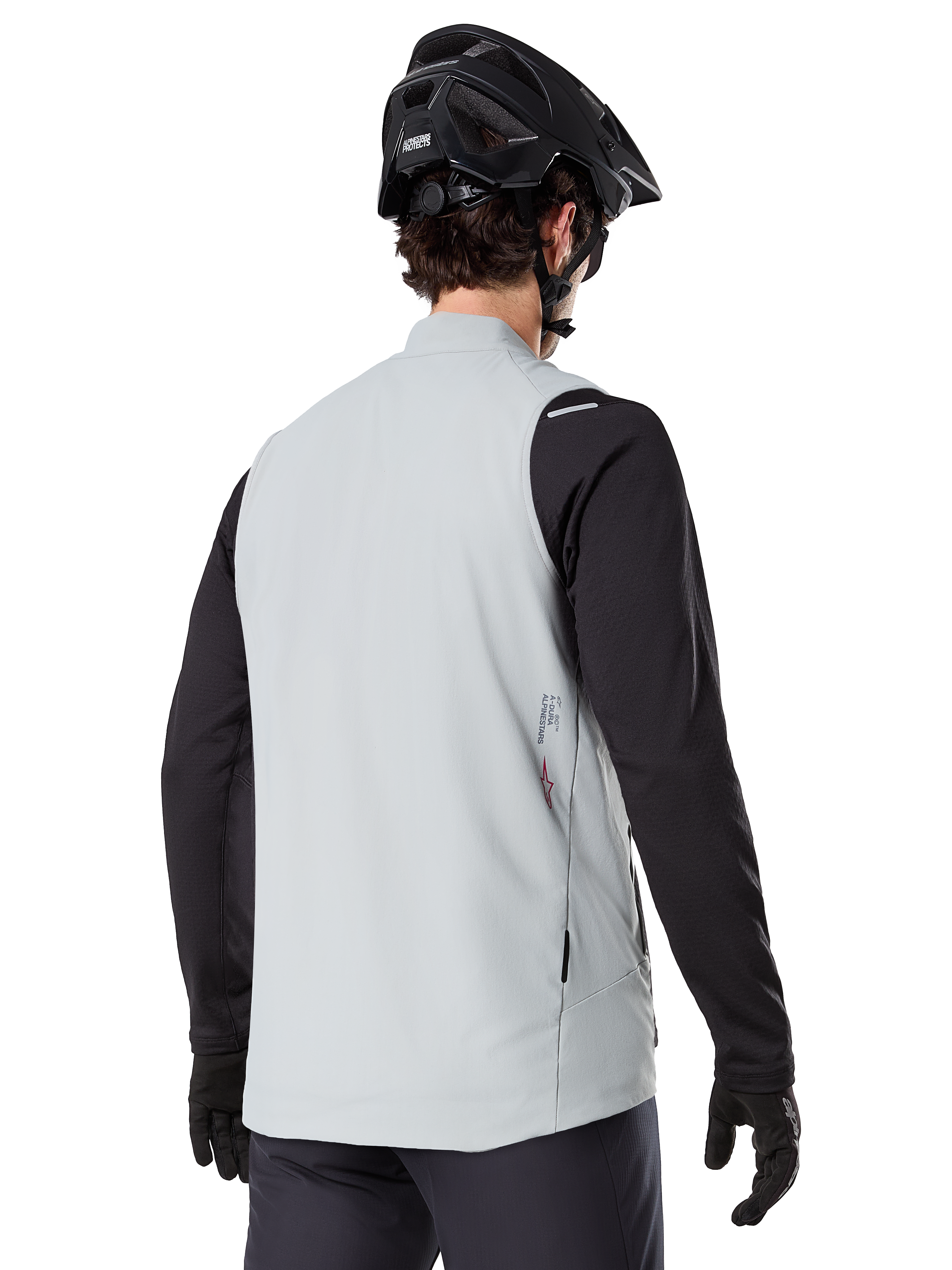 Alpinestars A-Dura Termovest, Titaniumgrå, set bagfra af model iført sort langærmet trøje og MTB-hjelm, minimalistisk design med et lille rødt stjernelogo på ryggen, letvægts isoleret cykelvest til off-road kørsel
