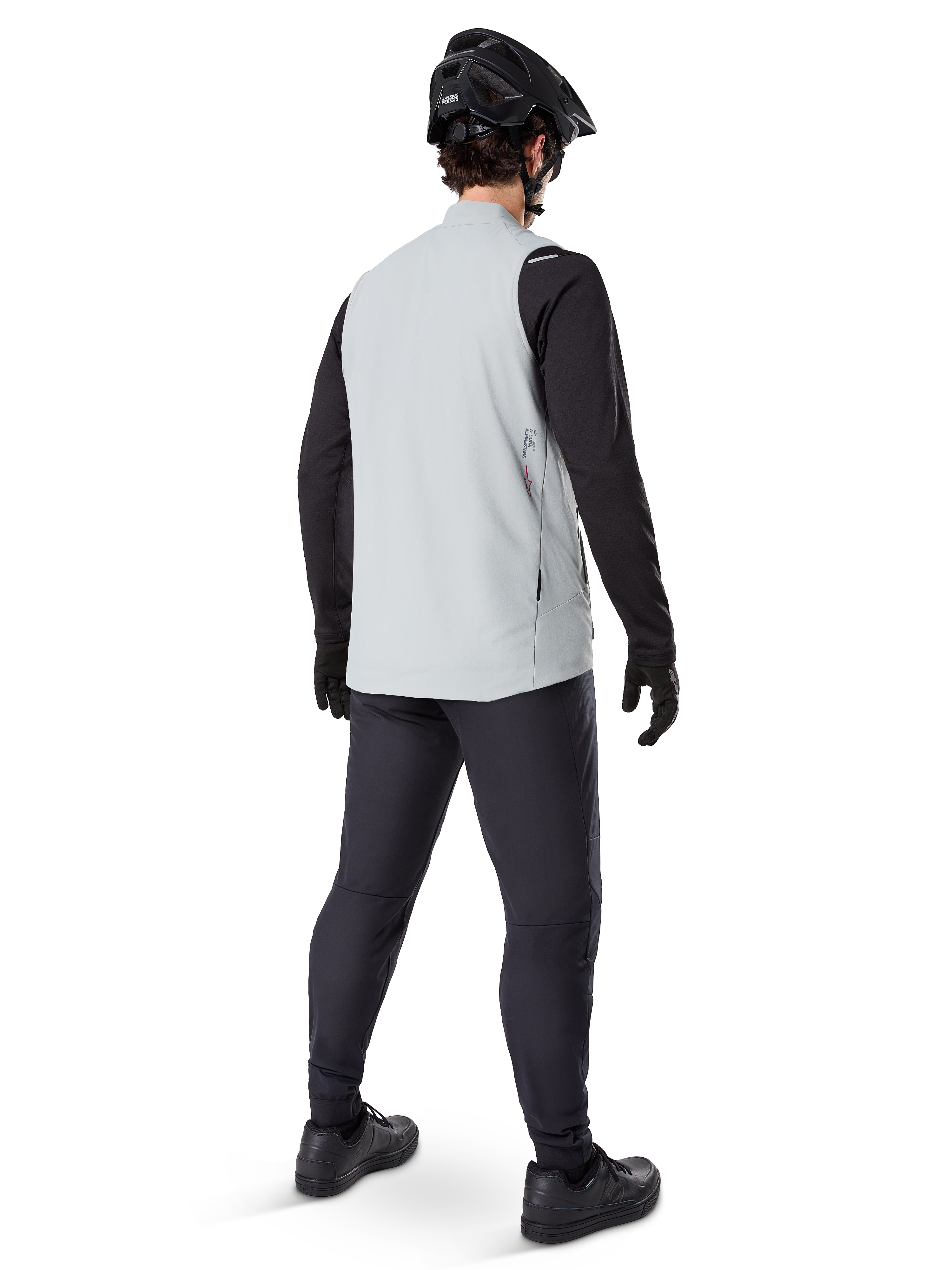 Alpinestars A-Dura Thermal Vest, Titanium Gray, set bagfra af model iført den isolerede cykelvest over en sort langærmet trøje og mørke bukser, komplet med en sort mountainbikehjelm og handsker, designet til terrænkørsel i koldt vejr