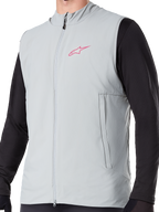 Alpinestars A-Dura termovest, titaniumgrå isoleret cykelvest, lyserødt stjernelogo på brystet, båret over en sort langærmet trøje, lodret lynlåslomme og gennemgående lynlås foran, designet til mountainbike-kørsel i koldt vejr