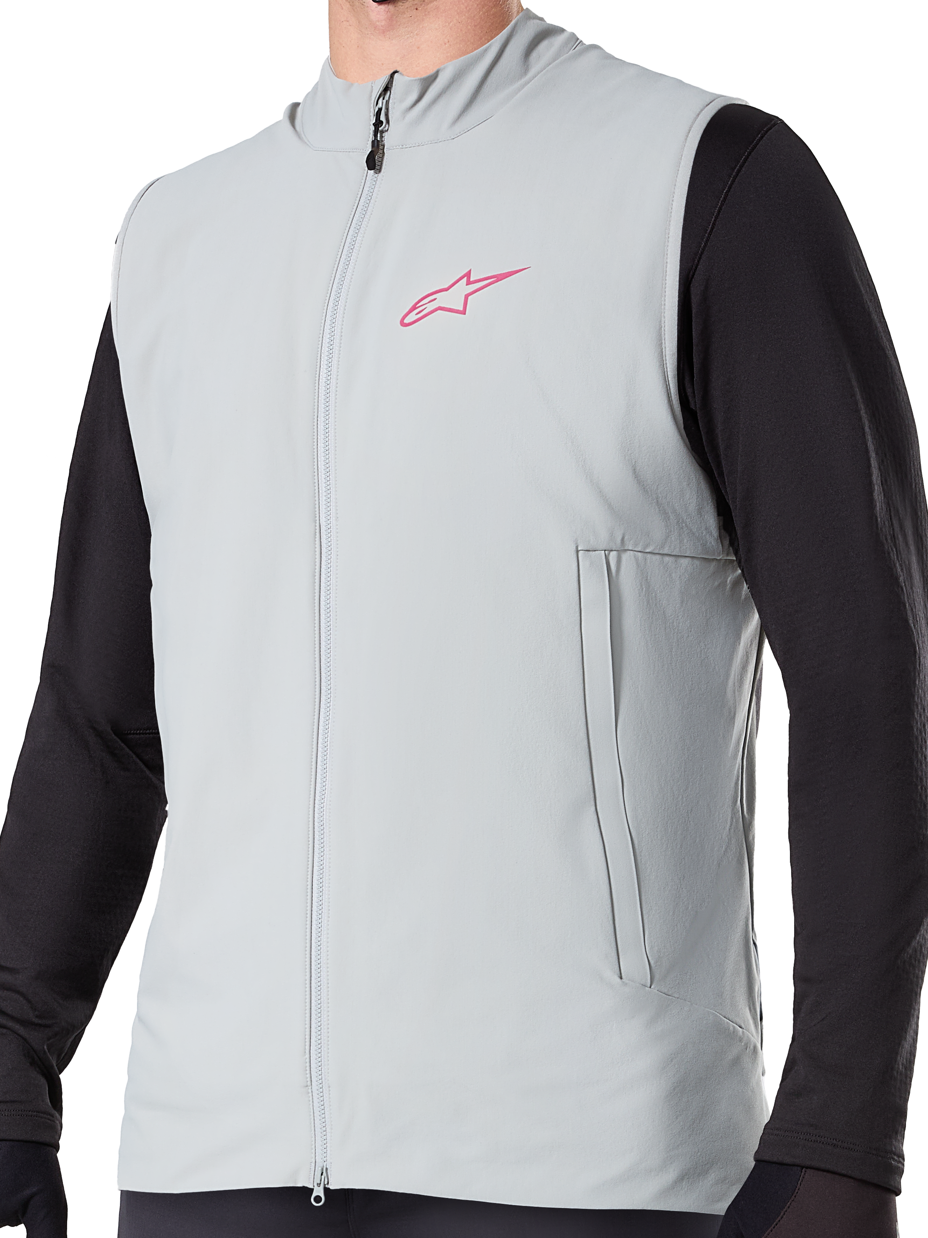 Alpinestars A-Dura termovest, titaniumgrå isoleret cykelvest, lyserødt stjernelogo på brystet, båret over en sort langærmet trøje, lodret lynlåslomme og gennemgående lynlås foran, designet til mountainbike-kørsel i koldt vejr