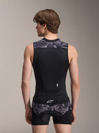 Alpinestars A-Motion Plasma beskyttelsesvest, Black Camo, set bagfra på mandlig model, åndbar mesh-konstruktion med integreret Nucleon Plasma rygbeskytter, grå camouflage-detaljer på skuldre og talje, Alpinestars-branding