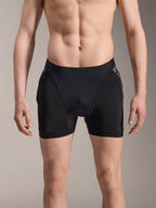 Alpinestars A-Motion Plasma beskyttelsesboxershorts, MTB-beskyttelsesshorts, sort med Black Camo-detaljer, set forfra på mandlig model, med åndbart strækmesh og integreret hoftebeskyttelse til cykling.