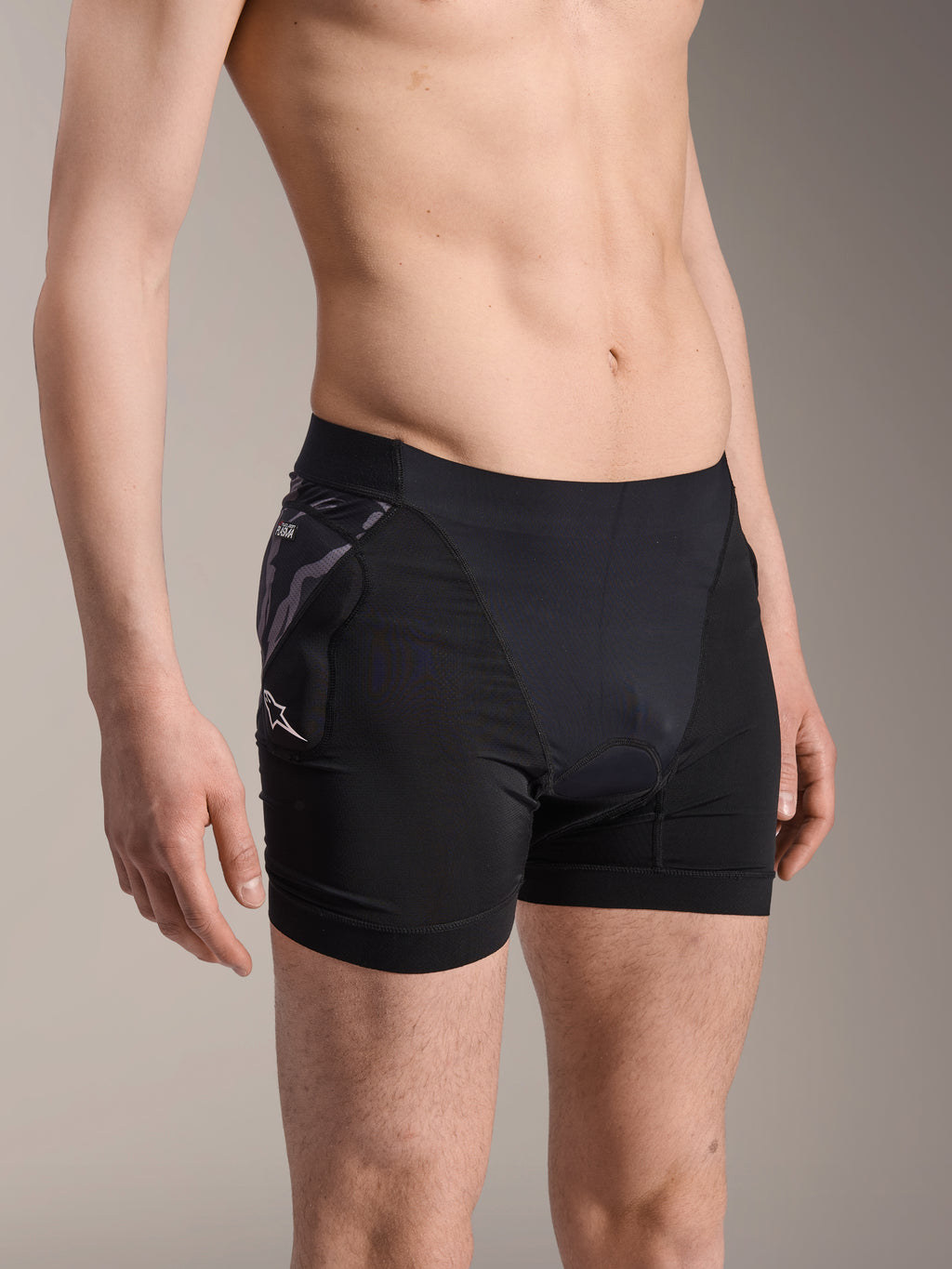 Alpinestars A-Motion Plasma Protection Boxers, sorte cykel-base-layer-shorts, med camo-mønstret hoftebeskytter og hvidt Astar-logo, åndbart mesh-stof, beskyttelsesudstyr til mountainbike
