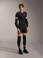 Mandlig model iført Alpinestars A-Motion Plasma Protection Jacket - Short Sleeve, Black Camo med gråmønstrede skuldre, central lynlås foran og hvidt brystlogo, kombineret med sorte arm- og knæbeskyttere, teknisk MTB-beskyttelsesudstyr til terrænkørsel.