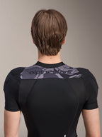 Alpinestars A-Motion Plasma beskyttelsesjakke - kortærmet, set bagfra af den øvre torso, sort med gråt camo-panel over skuldrene med Alpinestars-logo, åndbar strækbar mesh-konstruktion til MTB-beskyttelse