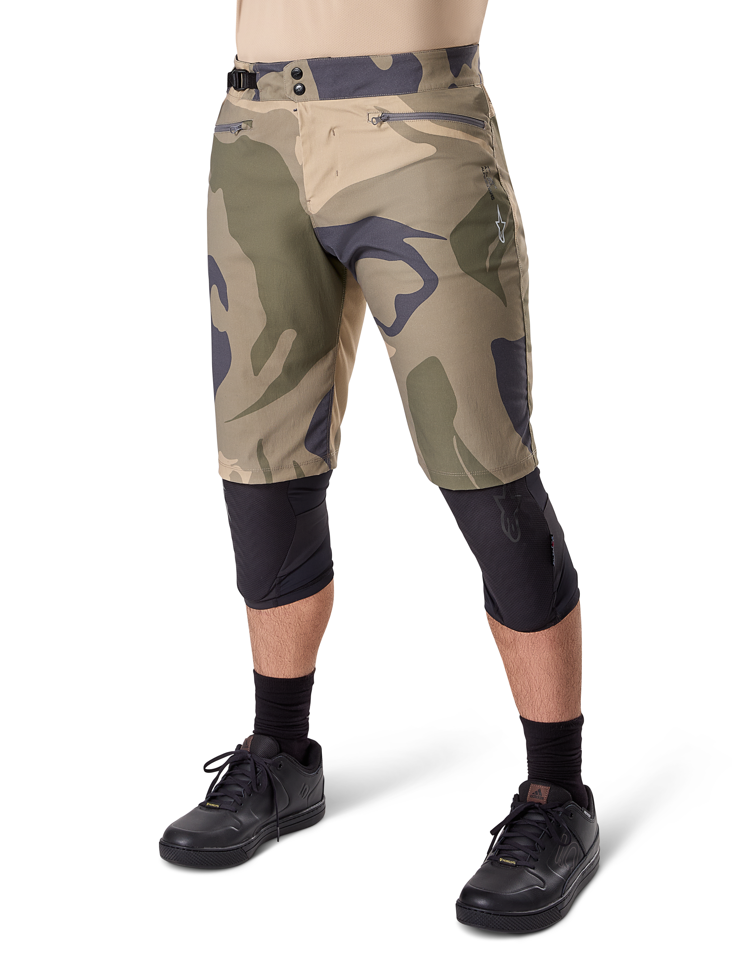 Alpinestars A-Dura Camo Liner Shorts, mountainbike-shorts, brunt camouflage-mønster, set forfra med lynlåslommer og taljejustering i siderne, båret med sorte knæbeskyttere og sorte cykelsko, slidstærkt udstyr til MTB