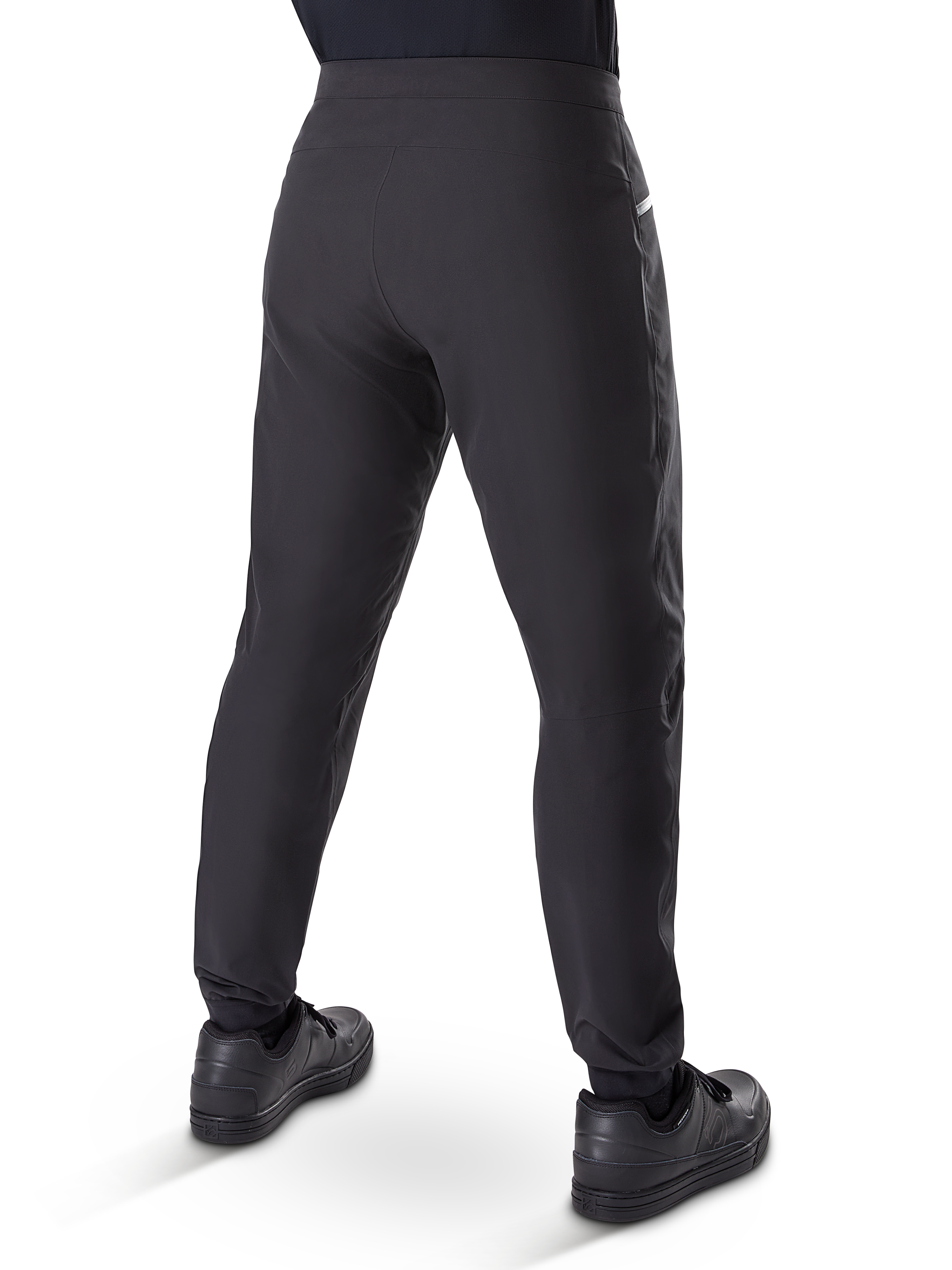 Alpinestars A-Dura vandtætte bukser, mountainbike-bukser, sort, set bagfra båret med sorte sko, med en holdbar 3-lags membran, almindelig pasform og elastiske manchetter til off-road cykling