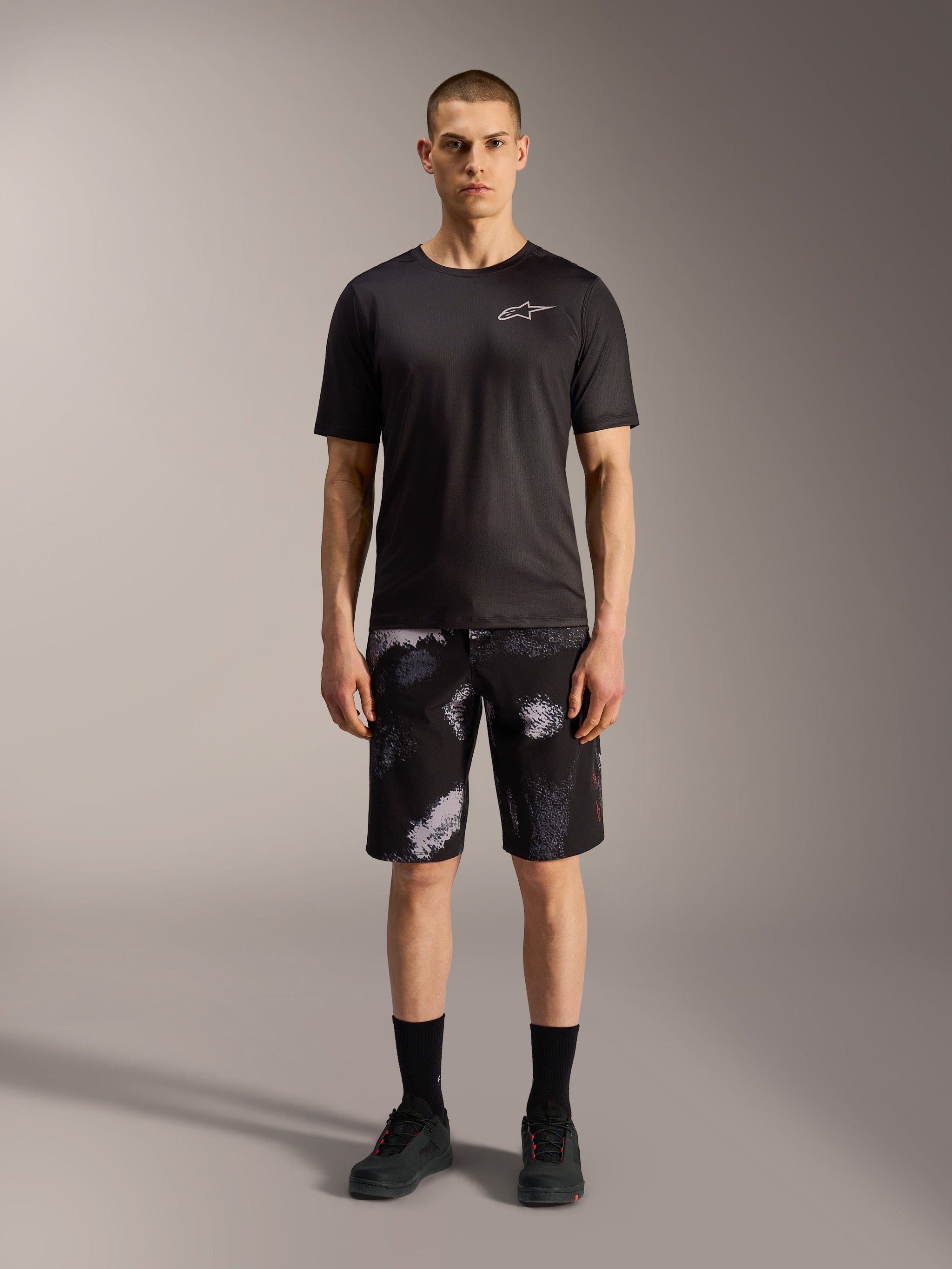 Alpinestars A-Dura Ride shorts i Black Camo, stylet med en sort performance-T-shirt til alsidig mountainbike-brug.
