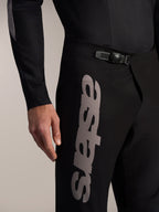 Sorte Alpinestars A-Supra Elite MTB-bukser med skraldespænde-lukning og et markant gråt Astars-logo på låret.
